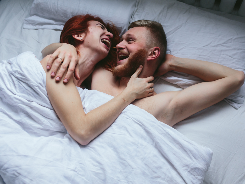 Koppel in een bed glimlachen naar elkaar