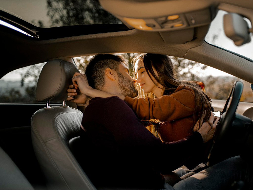 Koppel in auto geven elkaar kus